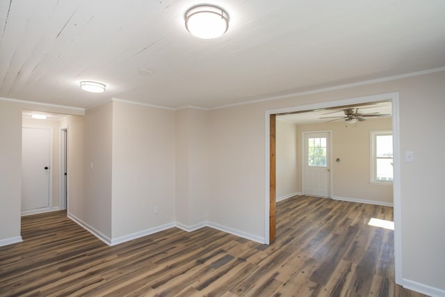 empty room with baseboards, ornamental molding, and dark wood-type flooring