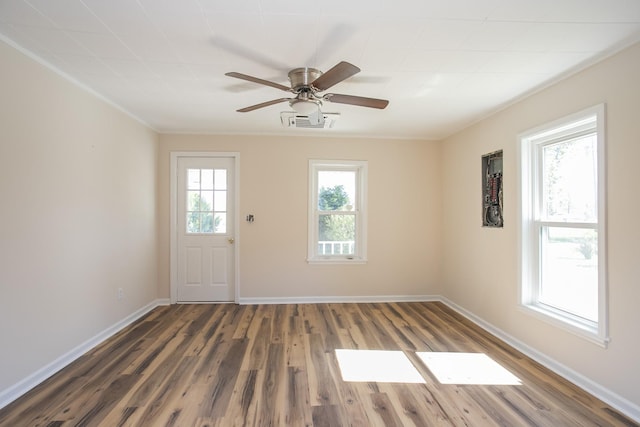 interior space with baseboards, visible vents, a ceiling fan, wood finished floors, and crown molding