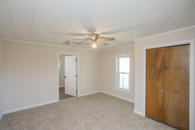 unfurnished bedroom featuring baseboards, ornamental molding, a ceiling fan, and light colored carpet