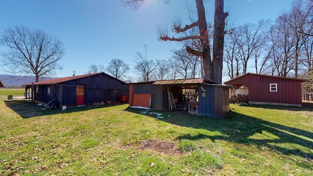 rear view of house with a pole building, a yard, and an outdoor structure