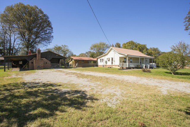 exterior space with a porch, a yard, driveway, crawl space, and a carport