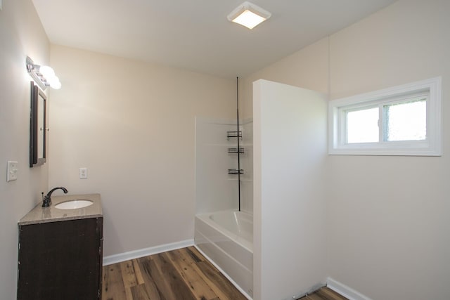 bathroom featuring bathtub / shower combination, baseboards, wood finished floors, and vanity