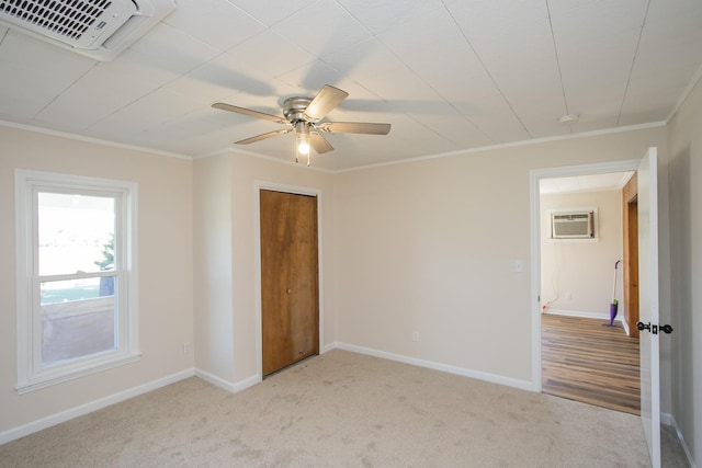 unfurnished bedroom with ornamental molding, light colored carpet, visible vents, and a wall mounted AC