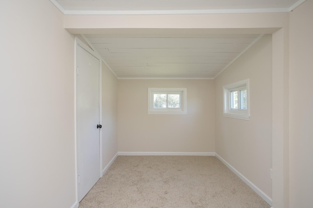 empty room with baseboards, ornamental molding, and light colored carpet