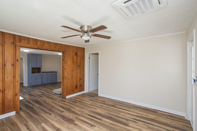 interior space with baseboards, visible vents, dark wood-style flooring, crown molding, and wood walls