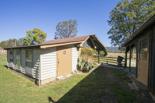 view of outbuilding featuring an outdoor structure and fence