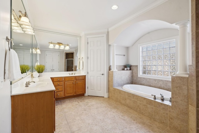 bathroom with double vanity, decorative columns, ornamental molding, a garden tub, and tile patterned flooring