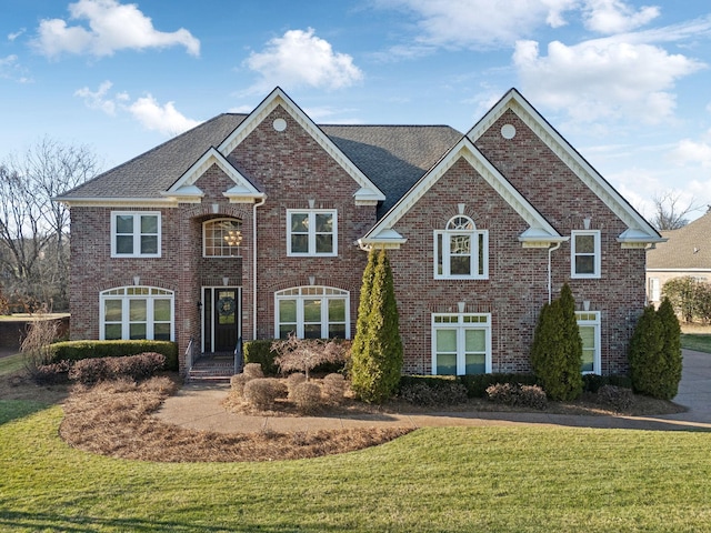 view of front of property featuring a front lawn and brick siding