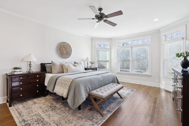 bedroom with multiple windows, crown molding, and wood finished floors