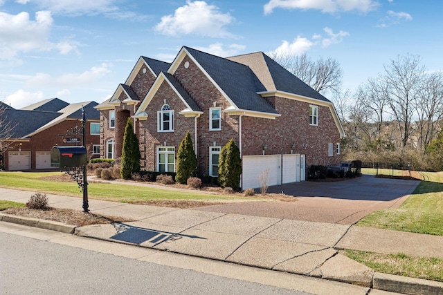 traditional-style home featuring an attached garage, brick siding, a shingled roof, driveway, and a front yard