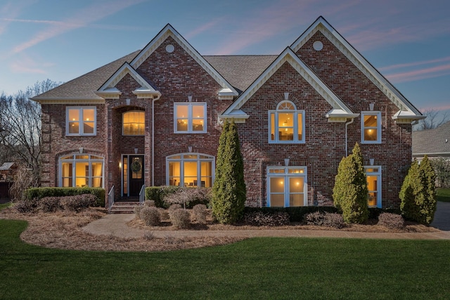 traditional home with brick siding and a front yard