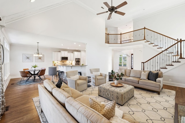 living area featuring stairs, light wood finished floors, ornamental molding, and baseboards