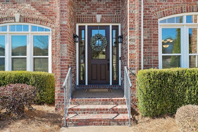 entrance to property featuring brick siding