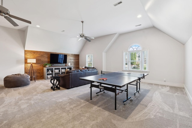 playroom featuring carpet, wooden walls, visible vents, and vaulted ceiling