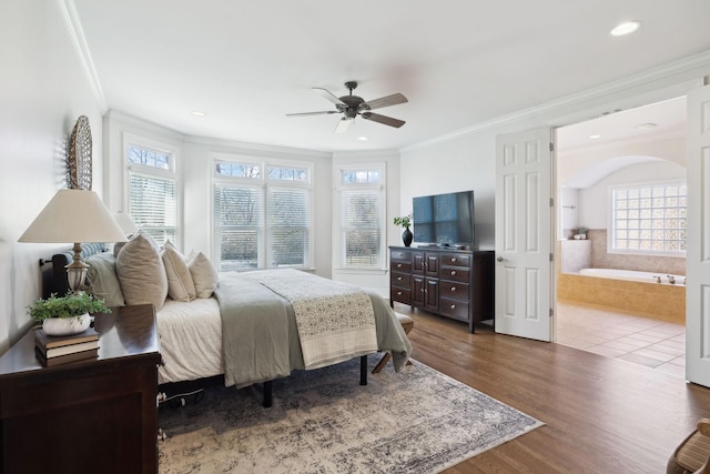 bedroom featuring ornamental molding, connected bathroom, dark wood finished floors, and ceiling fan