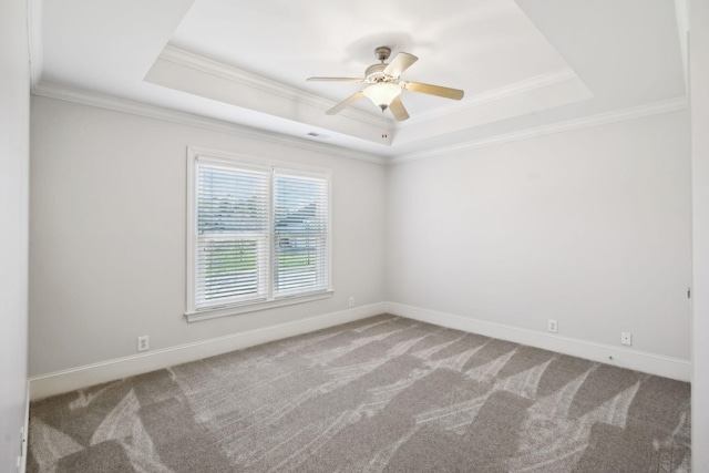 spare room featuring carpet floors, a tray ceiling, crown molding, and baseboards