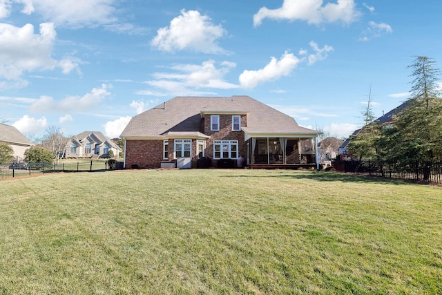 back of property featuring a lawn, a fenced backyard, and a sunroom