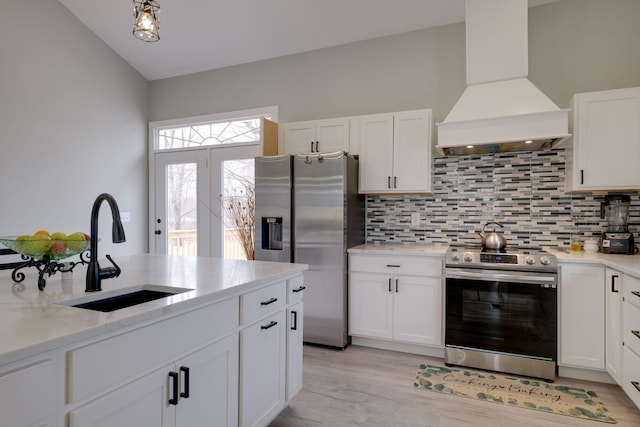 kitchen featuring stainless steel appliances, a sink, white cabinetry, custom exhaust hood, and decorative backsplash