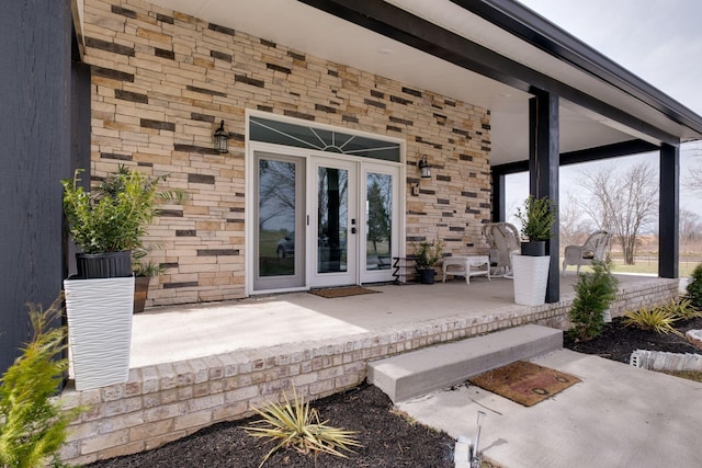 entrance to property featuring stone siding and french doors