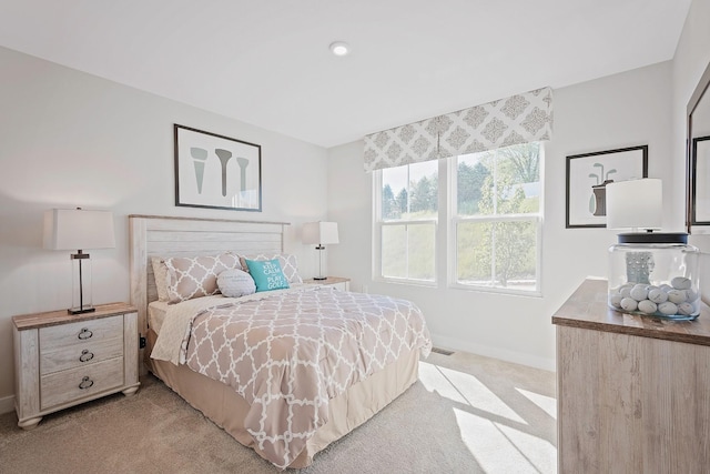 bedroom featuring light carpet and baseboards