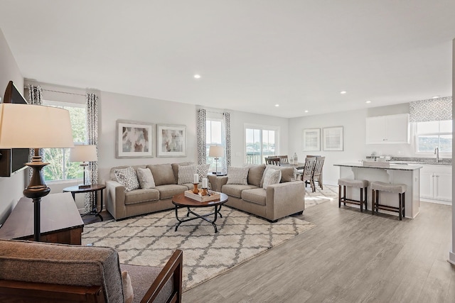 living area with light wood-type flooring, a wealth of natural light, and recessed lighting