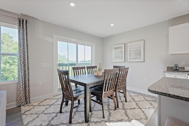 dining room with light wood-style floors, recessed lighting, and baseboards