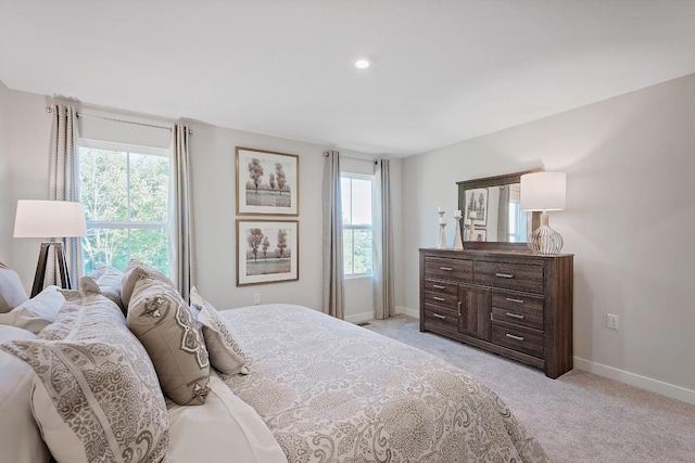 bedroom with light carpet and baseboards