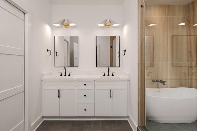 full bath with a soaking tub, a sink, baseboards, and double vanity