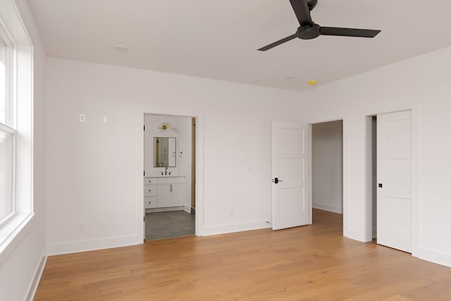 unfurnished bedroom with light wood finished floors, multiple windows, and baseboards