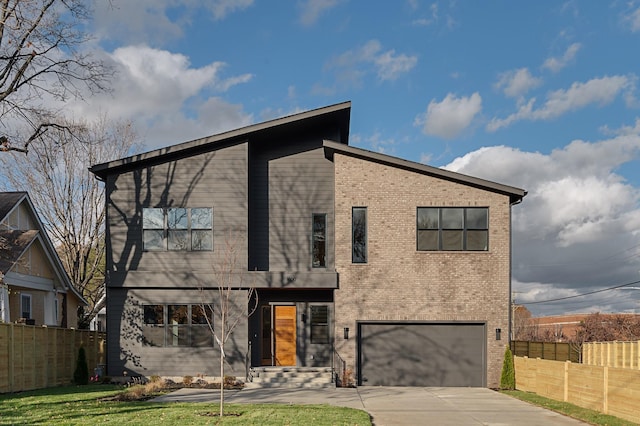 contemporary home featuring a garage, brick siding, fence, and driveway