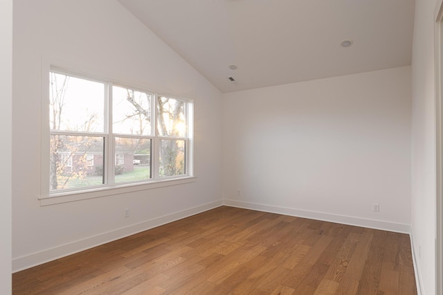 unfurnished room with lofted ceiling, baseboards, and light wood-style floors