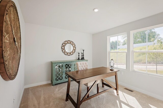 office space featuring light carpet, visible vents, and baseboards