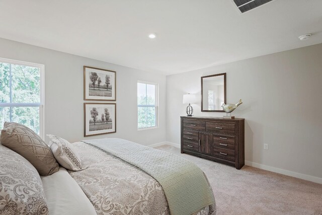 bedroom featuring light carpet, visible vents, and baseboards