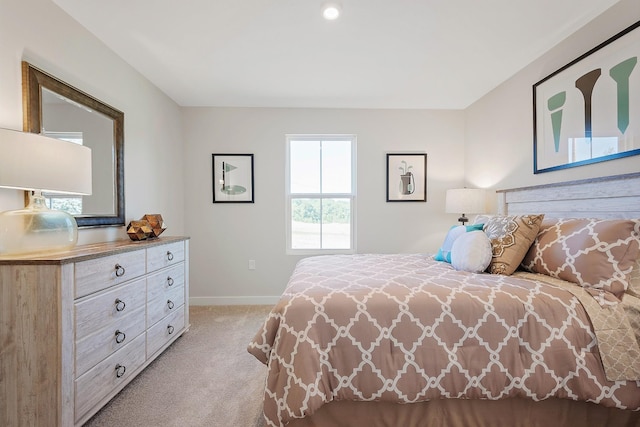 bedroom with baseboards and light colored carpet