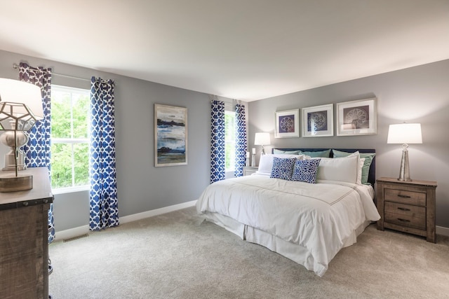 bedroom featuring light colored carpet, visible vents, and baseboards