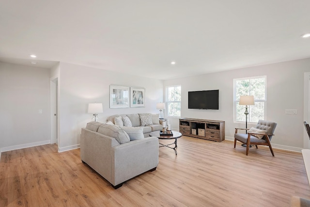 living area with recessed lighting, baseboards, and light wood finished floors