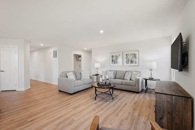 living room with light wood-type flooring, visible vents, baseboards, and recessed lighting