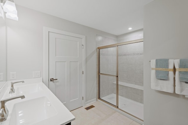 full bathroom with recessed lighting, visible vents, a tile shower, and a sink