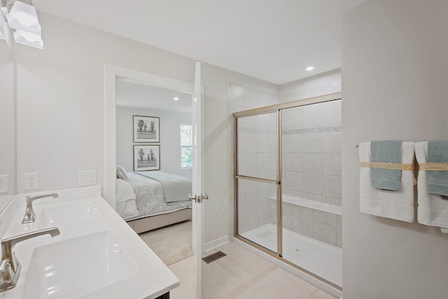 ensuite bathroom with recessed lighting, visible vents, ensuite bathroom, a tile shower, and a sink