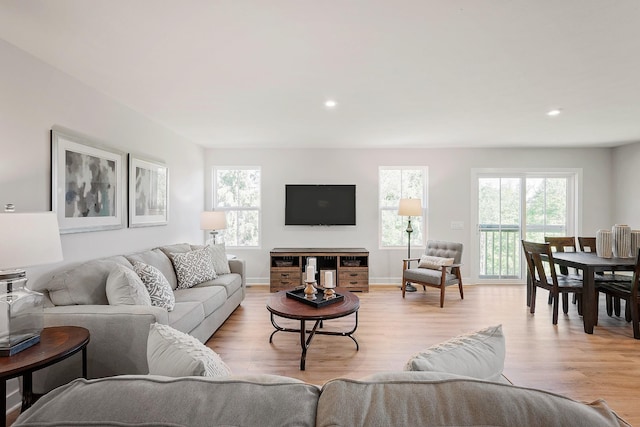 living room with recessed lighting, baseboards, and light wood finished floors