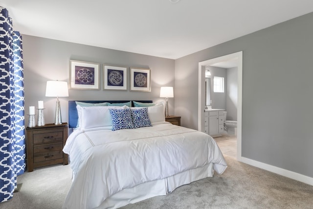 bedroom featuring light carpet, connected bathroom, and baseboards