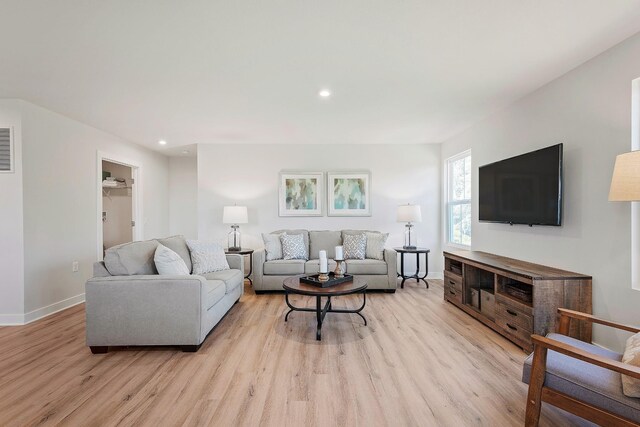 living room featuring light wood finished floors, baseboards, and recessed lighting