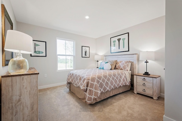 bedroom with light carpet and baseboards