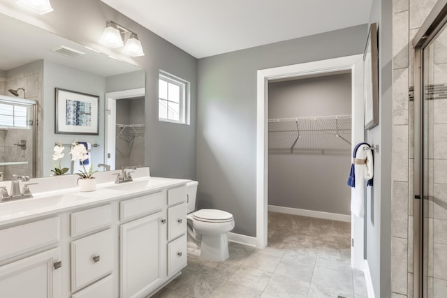 bathroom with toilet, a stall shower, a sink, and visible vents