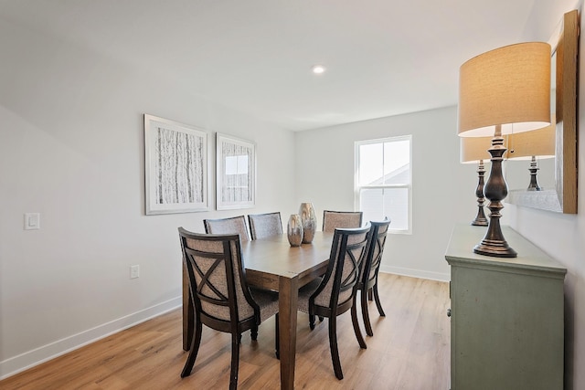 dining room with light wood-type flooring, baseboards, and a wealth of natural light