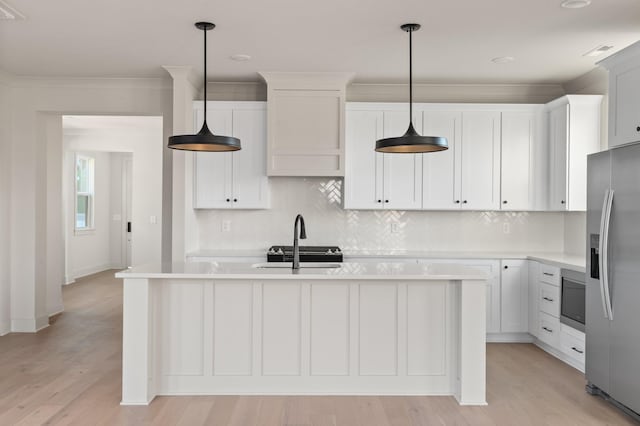 kitchen with stainless steel appliances, light countertops, backsplash, a sink, and light wood-type flooring