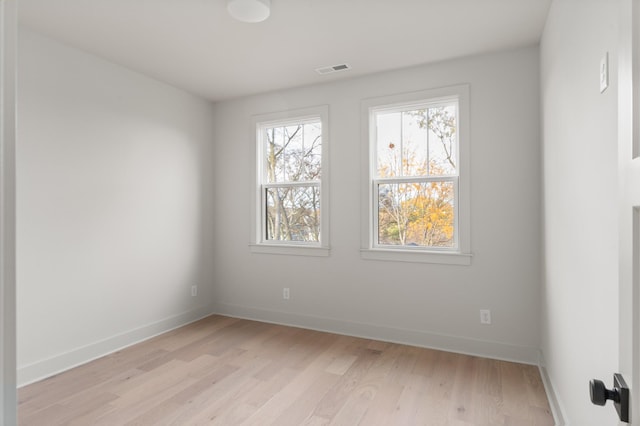 spare room with visible vents, light wood-style flooring, and baseboards