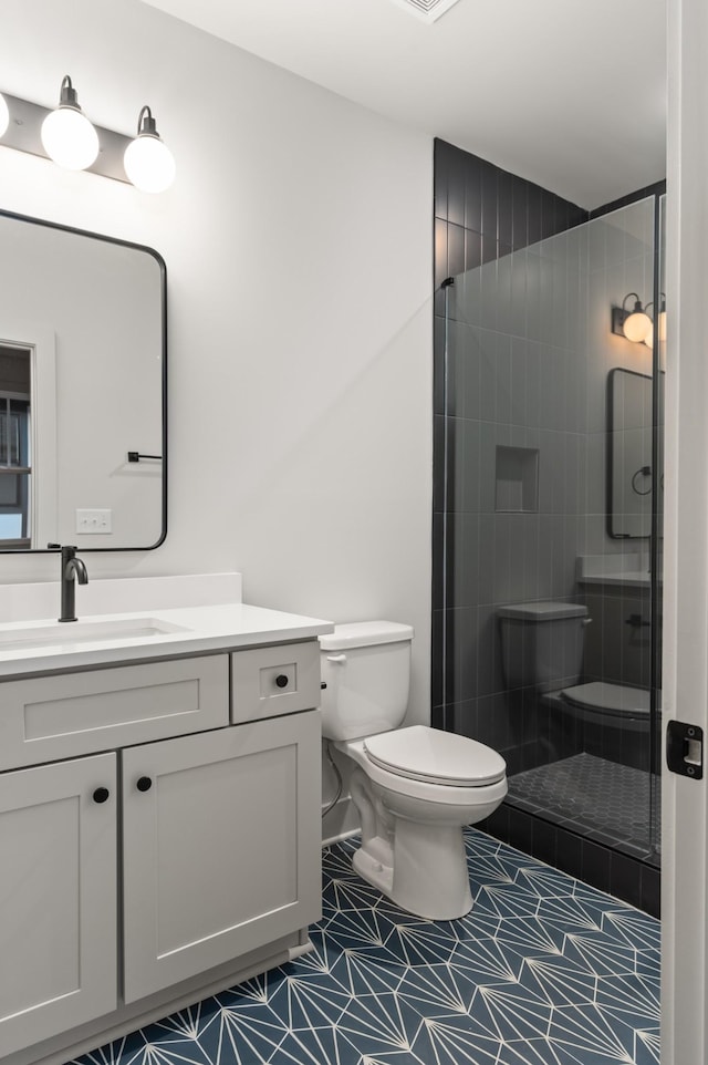 full bath with toilet, a stall shower, tile patterned floors, and vanity