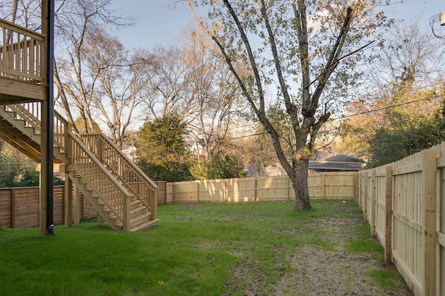 view of yard with a fenced backyard, stairway, and a wooden deck