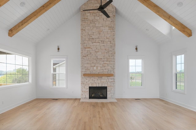 unfurnished living room featuring a wealth of natural light, ceiling fan, and beamed ceiling